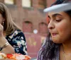 Two people are smiling at the camera while biting into large slices of pizza