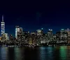 A persons silhouette in the foreground looks towards a cloudy Manhattan skyline featuring the One World Trade Center