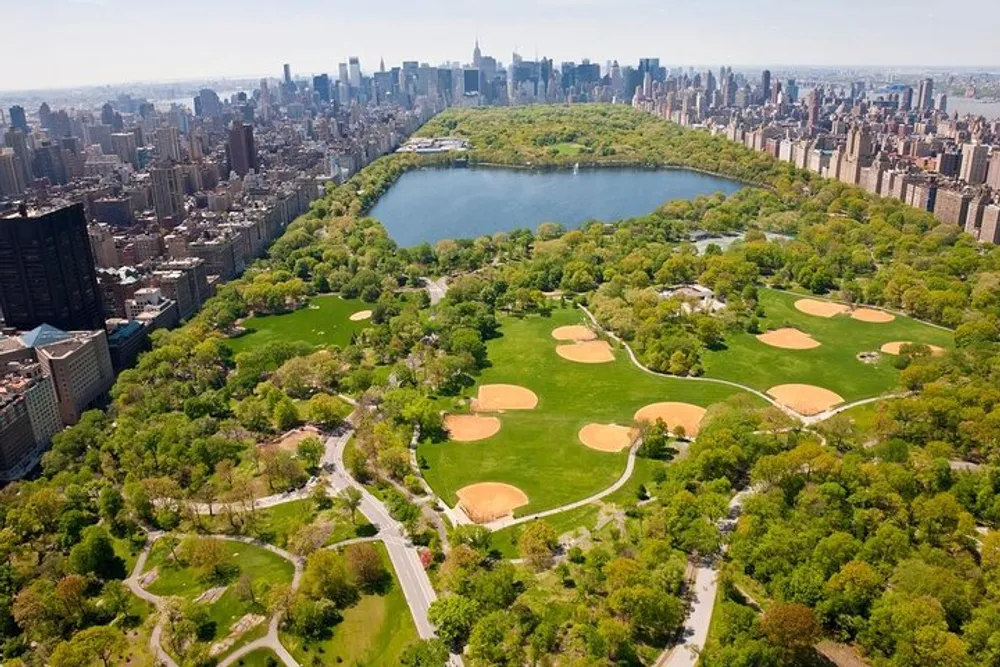 An aerial view of Central Park in New York City showcasing its lush greenery pathways and the contrast between the parks natural beauty and the surrounding urban skyline