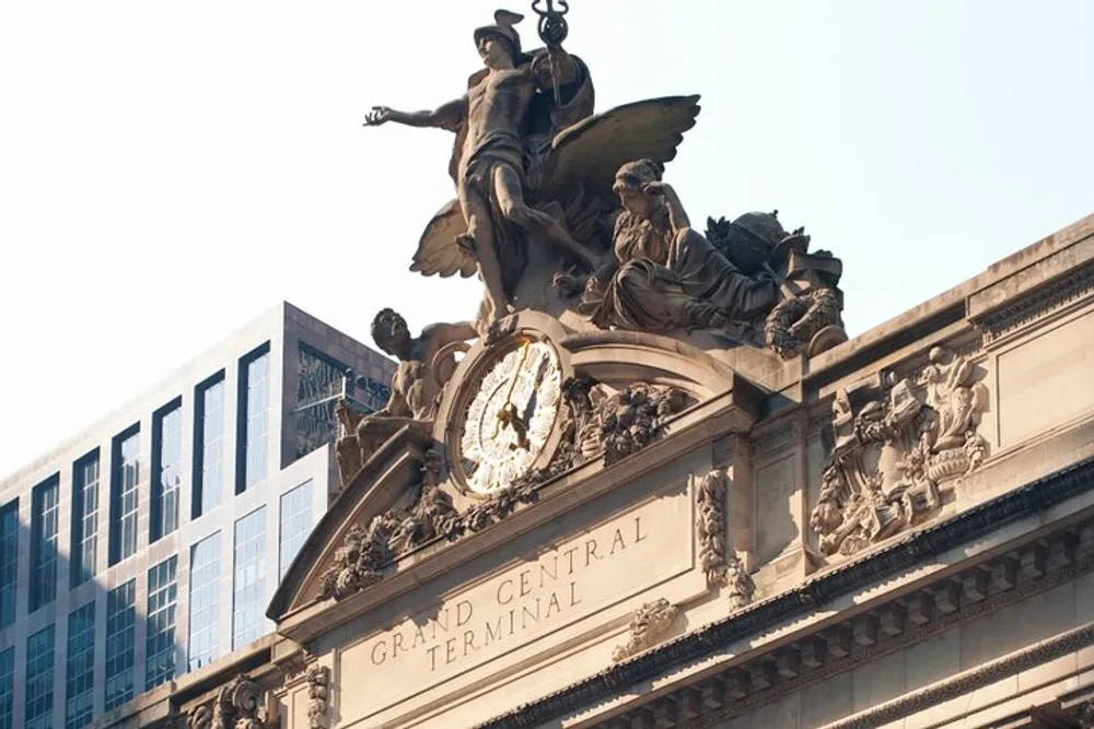 The image shows the sculpture and clock on the faade of Grand Central Terminal symbolizing glory and grandeur under a clear sky