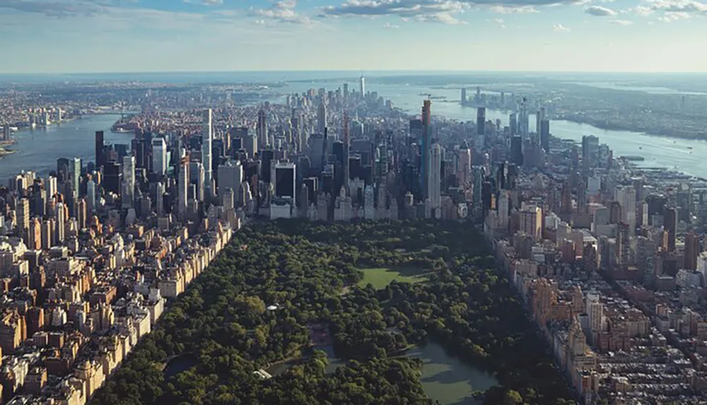 The image showcases an aerial view of Central Park in New York City surrounded by densely packed skyscrapers on a sunny day