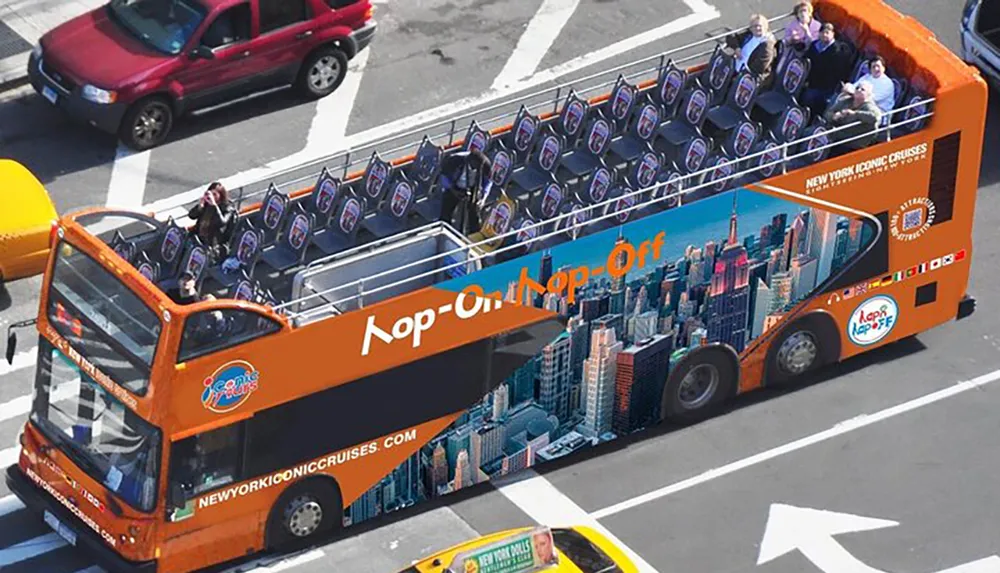 The image shows an open-top double-decker sightseeing bus with passengers labeled Hop-On Hop-Off advertising New York Iconic Cruises