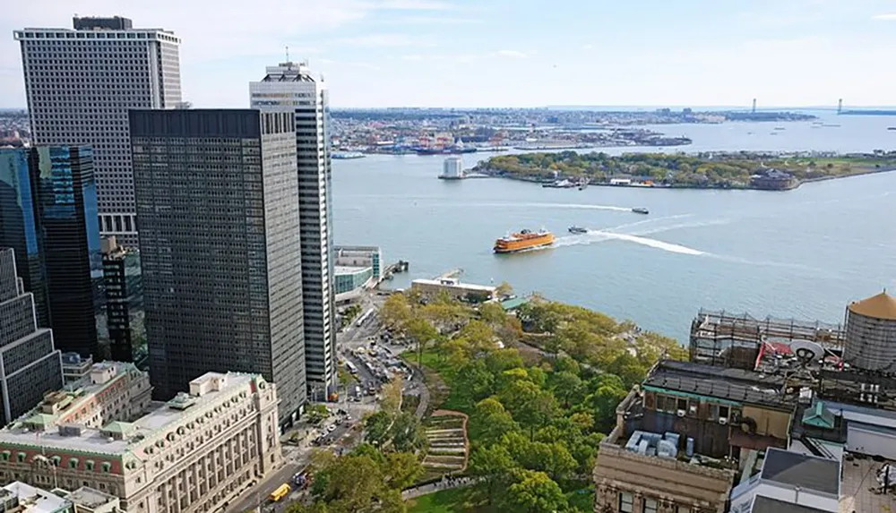 An aerial view of a busy waterway with ferries and boats overlooking a metropolitan area with high-rise buildings adjacent to a park