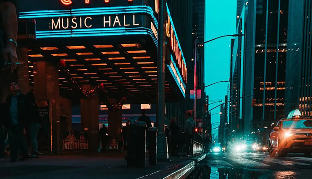 The image showcases an evening city scene with pedestrians and cars illuminated by the retro neon signage of the Music Hall