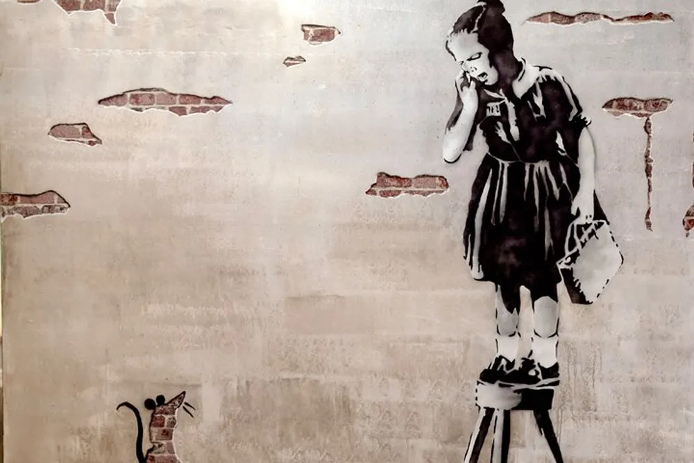 A monochromatic stencil graffiti artwork depicts a young girl on a raised platform apparently speaking on a phone while a small rat looks on from below