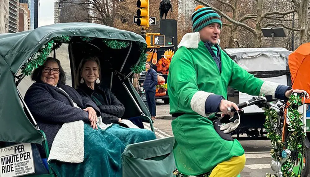 Two passengers are enjoying a festive rickshaw ride with a cyclist dressed in colorful clothing at the handlebars