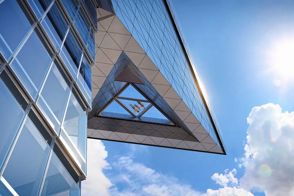 The image shows a modern building with geometric architectural features and reflective glass facade against a blue sky with sunlight peeking through