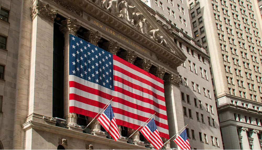 The image shows large American flags draped on the facade of the New York Stock Exchange symbolizing patriotism and the financial strength of the United States