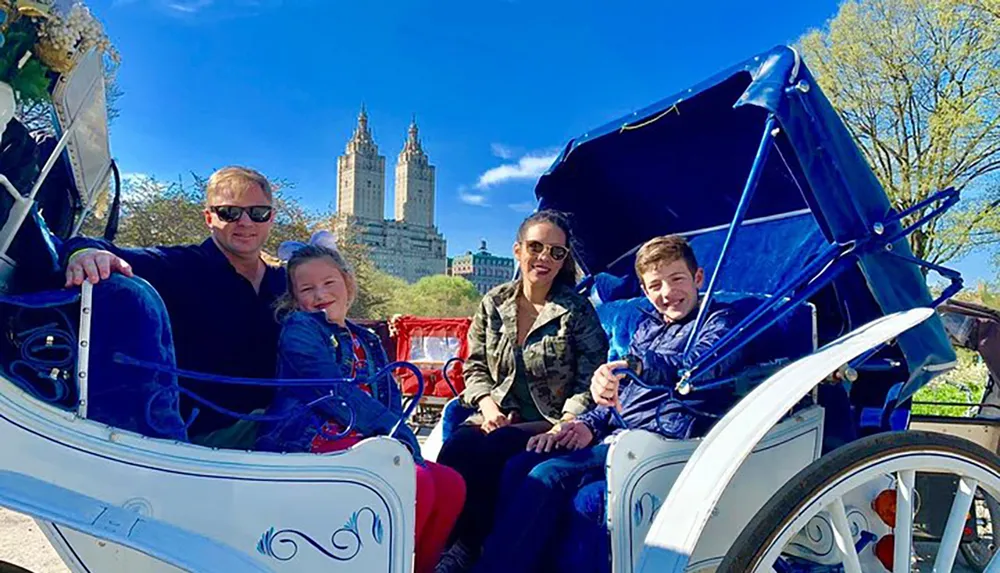 A family is enjoying a horse-drawn carriage ride with a backdrop of grand buildings on a sunny day