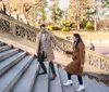 A couple is sharing an intimate moment of closeness while sitting on stone steps giving the impression of happiness and affection