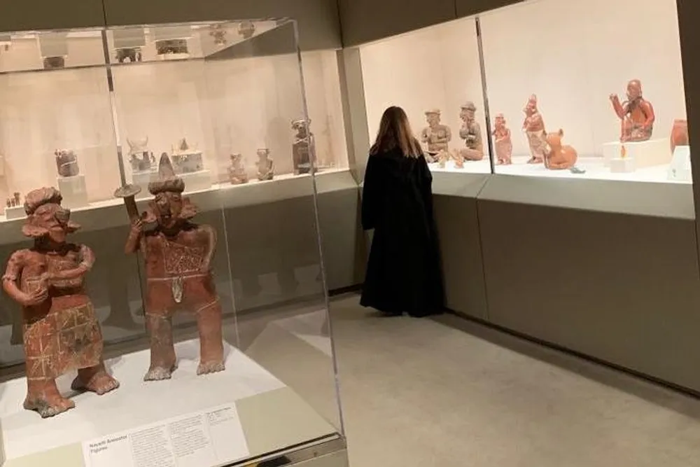 A person is viewing ancient artifacts displayed in a museum exhibit