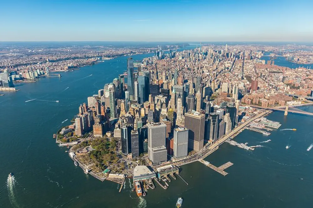 An aerial view of Lower Manhattan showcasing the dense array of skyscrapers and architecture distinct to New York City with the Hudson River framing the area