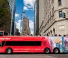 A smartphone displaying an attraction pass with a QR code is superimposed on a scenic backdrop featuring the Statue of Liberty and New York City skyline