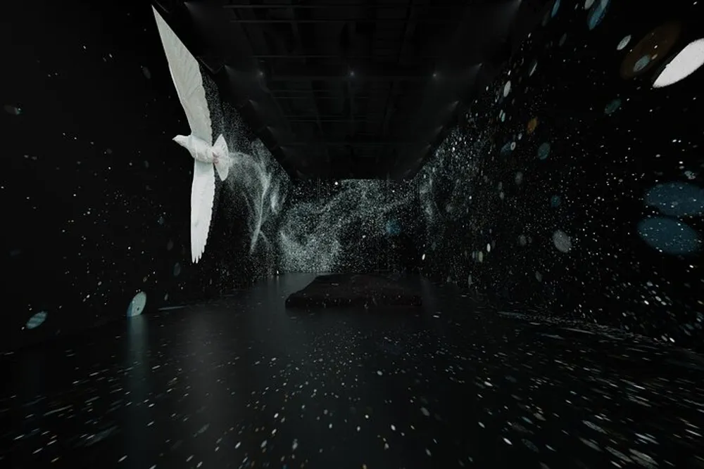 The image depicts an artistic dark interior space with a digitally created sensation of flying birds and scattered luminescent particles giving the impression of dynamic ethereal motion