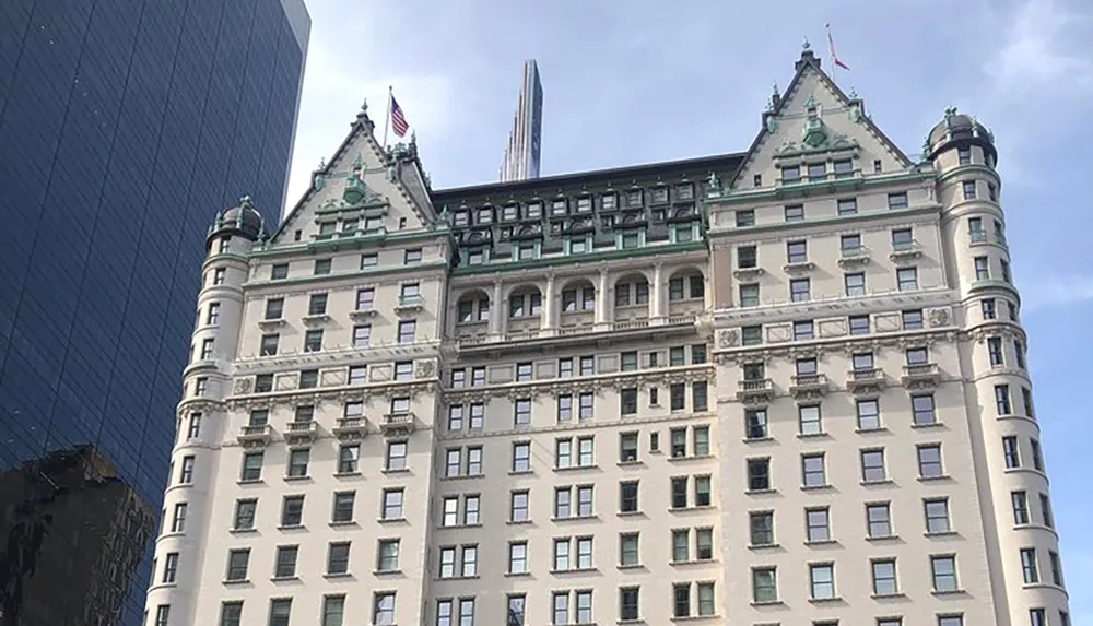 The image features the historic Plaza Hotel in New York City contrasting with the modern skyscraper in the background