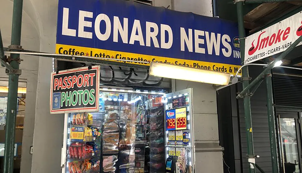 This image shows the storefront of Leonard News Inc advertising various products and services including coffee lotto cigarettes soda phone cards and passport photos