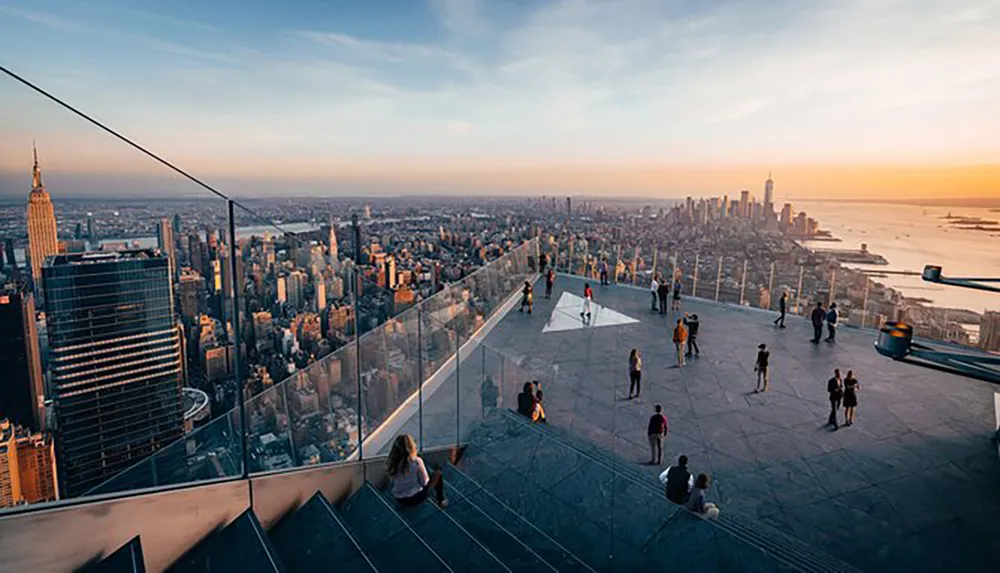 Visitors enjoy a breathtaking view of a cityscape from a high vantage point at sunset
