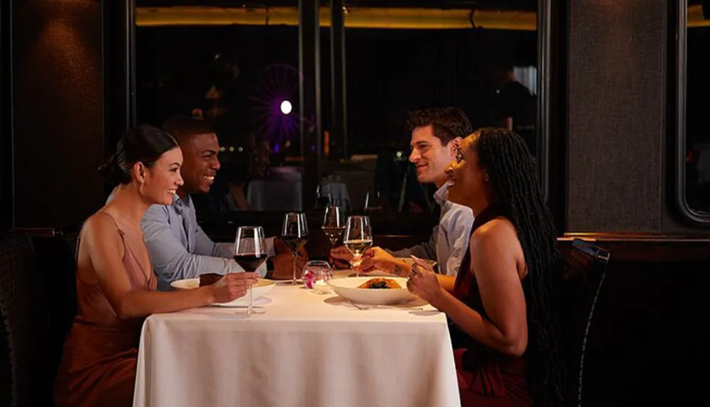 Two couples enjoy a cheerful dinner at a restaurant with a view of a Ferris wheel in the background