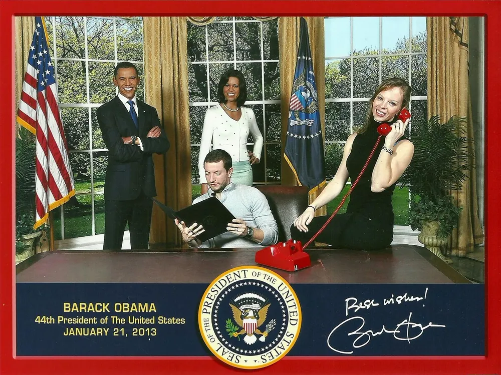 This is a novelty photo showing two individuals posing playfully in a faux Oval Office setup with cardboard cutouts of Barack Obama and another person standing in the background