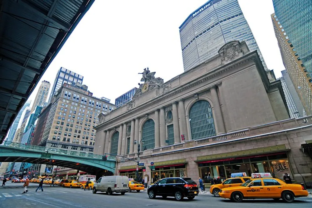 The image captures a bustling urban street scene with iconic yellow taxis pedestrians and the grand facade of a historic building