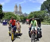 Three passengers are enjoying a festive pedicab ride with a driver dressed in a holiday-themed outfit giving a thumbs-up gesture