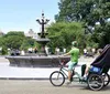 Three passengers are enjoying a festive pedicab ride with a driver dressed in a holiday-themed outfit giving a thumbs-up gesture