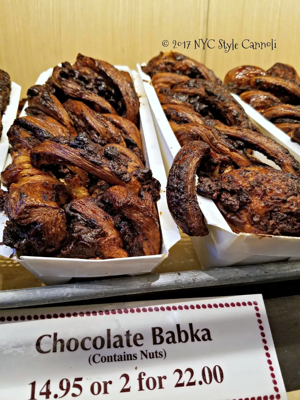 Trays of chocolate babka are displayed for sale at a price of 1495 each or two for 2200 with a note that they contain nuts