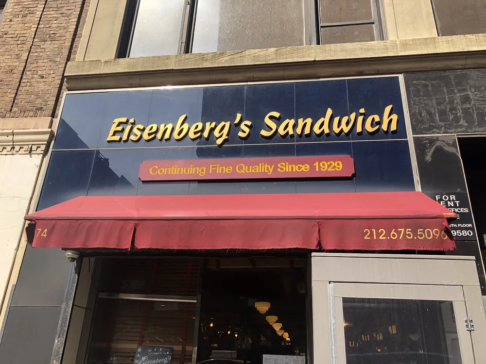 The image shows the facade of Eisenbergs Sandwich shop with a sign indicating it has been offering Continuing Fine Quality Since 1929 and is located at number 74 with an advertisement for office space for rent above the awning