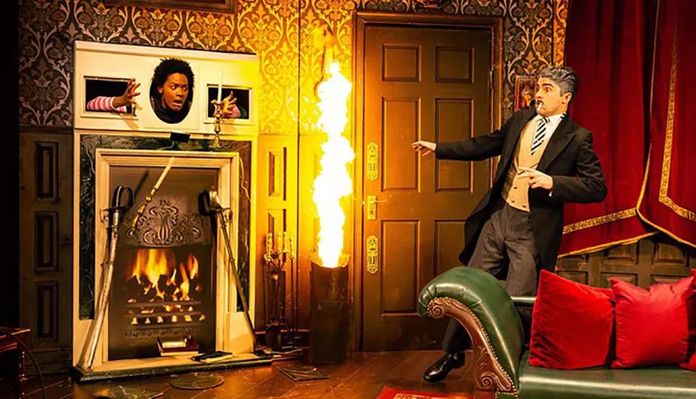 A person is sticking their head and hands through a painting above a fireplace while another person reacts in shock to a sudden burst of flame coming from the direction of a door in a lavishly decorated room