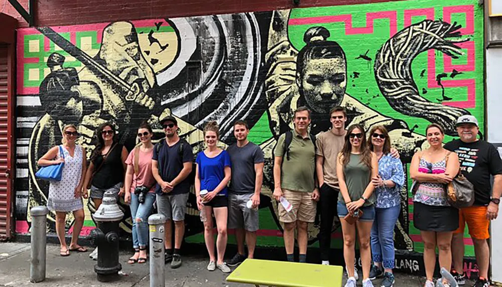 A group of people are posing for a photo in front of a vibrant street mural