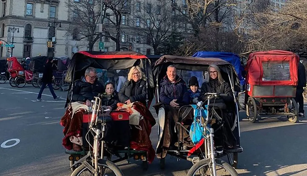 Tourists are enjoying rides in pedicabs on a sunny day possibly in an urban park setting