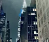 The image shows a vibrant and bustling Times Square at night illuminated by bright billboards and alive with the iconic yellow cabs of New York City