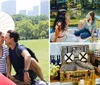 A couple enjoys a sunny picnic in a grassy park with a white parasol and the city skyline in the background