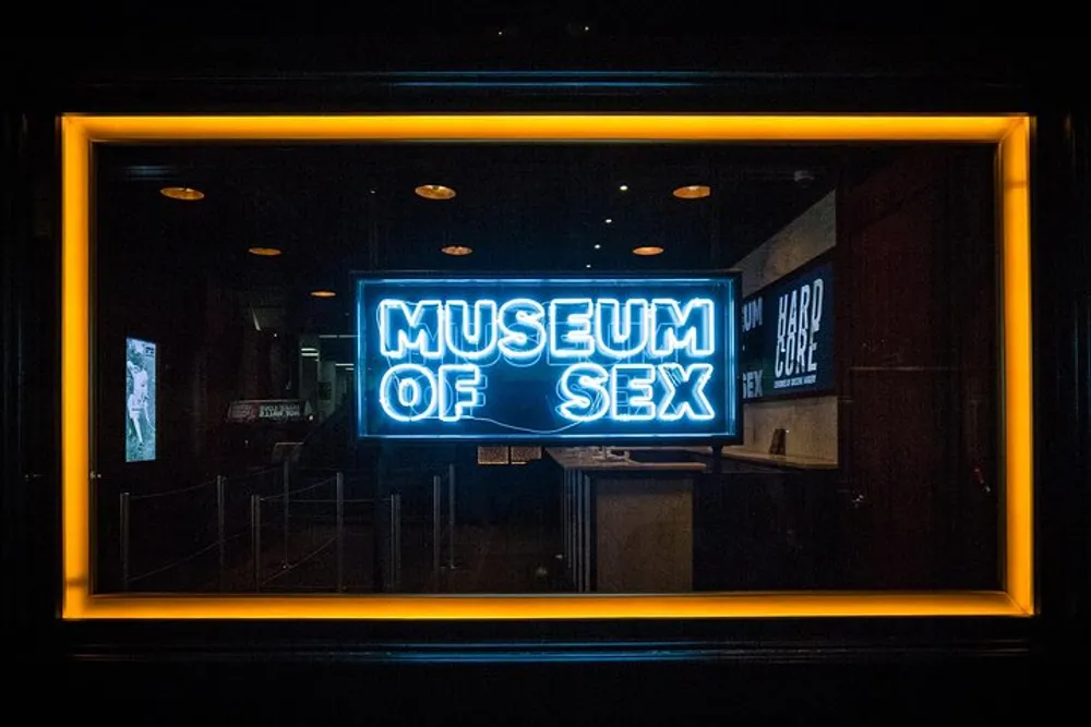 A neon sign reads Museum of Sex within a brightly lit border indicating the entrance to an adult-themed museum