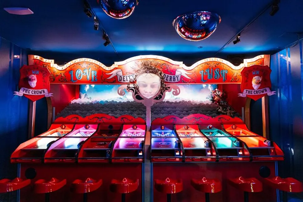 The image shows an arcade style racing game called Derby with a colorful setup illuminated by pink and blue lights and decorative elements evoking a carnival vibe