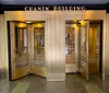 The image shows the ornate gold and brass entrance doors of the Chanin Building featuring Art Deco style architecture
