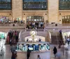 A group of people appears engaged in conversation near the entrance of Grand Central Terminal on a cloudy day with street signs for East 42nd Street and Park Avenue visible above them