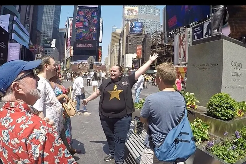 A group of people is interacting with each other in a lively Times Square on a sunny day