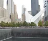 This image captures the 911 Memorial with its twin reflecting pools in the foreground and the architecturally distinctive Oculus structure in the background surrounded by the skyscrapers of Lower Manhattan