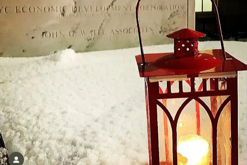 A red lantern is glowing warmly against a snowy backdrop