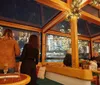 A person wearing a Santa hat is facing away from the camera overlooking a festive and warmly-lit interior adorned with holiday decorations