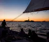 A man and a woman share a cheerful moment on a sailboat with the Statue of Liberty in the background during dusk