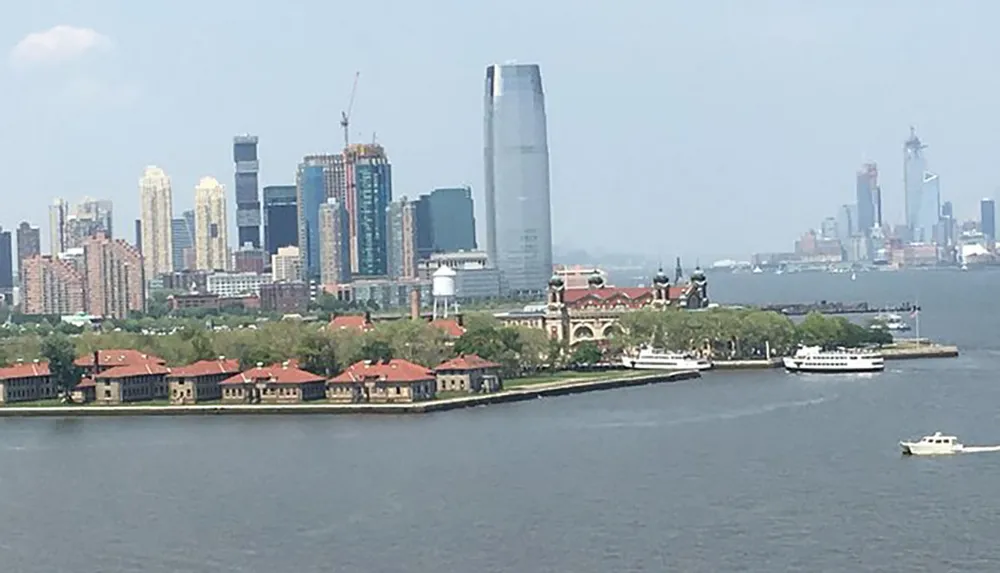 The image shows an urban skyline with skyscrapers behind a historic island complex with boats visible on the water in the foreground
