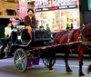 A horse-drawn carriage is navigating through a bustling Times Square lit by colorful billboards and signs at dusk