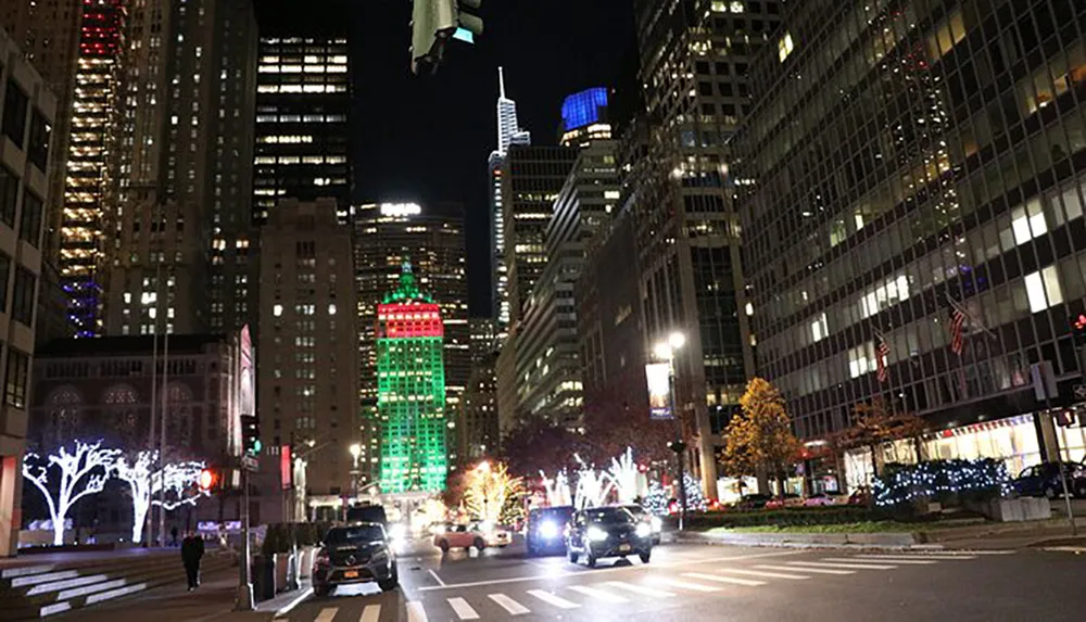 The image depicts a bustling urban street at night illuminated by the festive lights of surrounding skyscrapers and decorated trees creating a vibrant cityscape