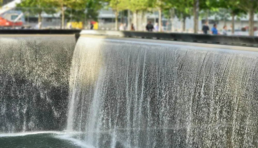 A cascading urban waterfall in a public space with blurred people in the background