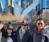 A group of five people is smiling for a photo in front of the Oculus structure in New York City on a sunny day