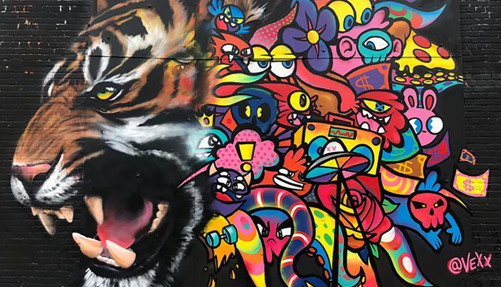 The image shows a vibrant street mural blending the realistic depiction of a roaring tigers face on the left with a colorful abstract cartoonish art style on the right