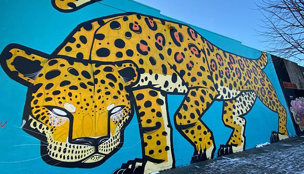 The image features a large colorful mural of a jaguar with a vibrant blue background on an urban wall