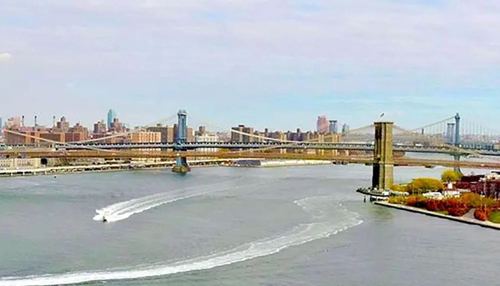 The image shows a river with a speedboat moving past a bridge leaving a wake behind with a city skyline in the background